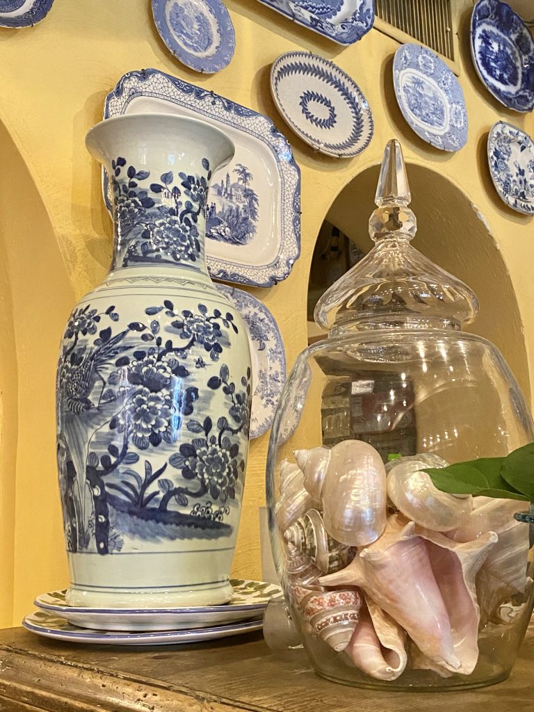 blue and white china hung on yellow walls, seashells