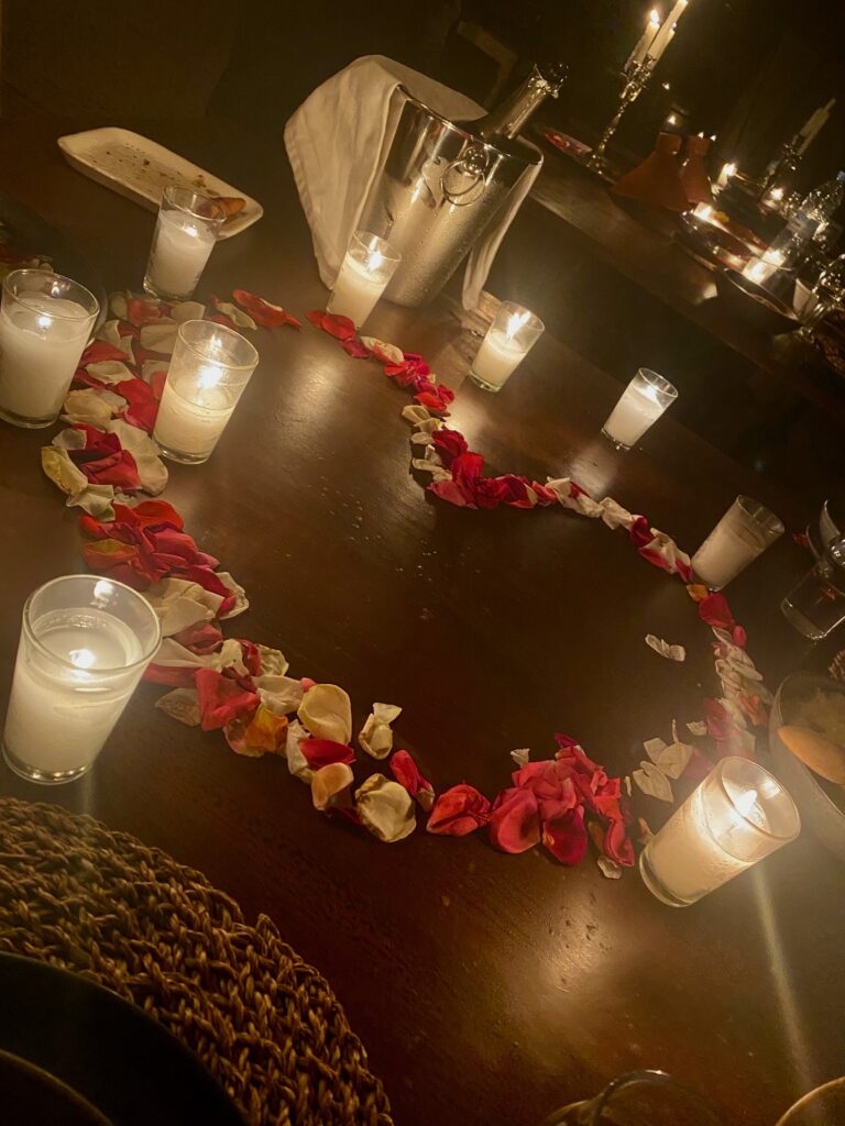 Rose petals, heart shaped rose petals, Billecart salmon champagne, candles, votive candles, elegant food in a rustic setting, Scarabeo Camp, Agafy desert, Morocco, tent dining, nomadic life, luxury tent living, indoor outdoor living, indoor outdoor dining