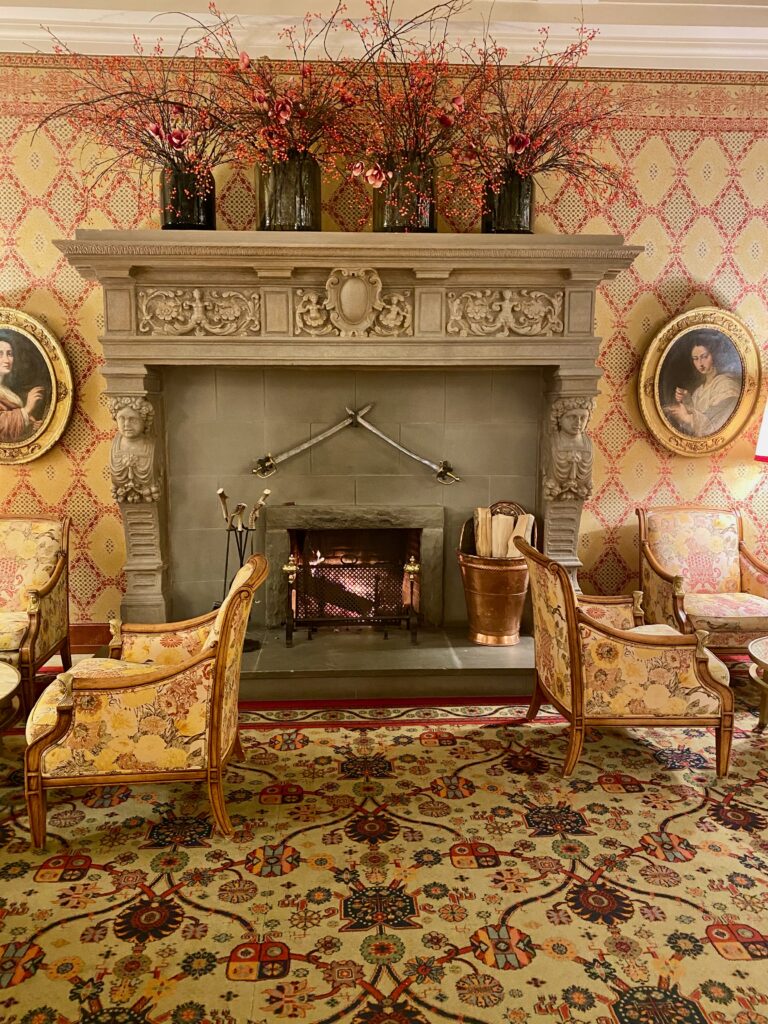 Smoky Paloma, fresh flowers, Hotel Kulm, St. Moritz, large fireplace mantel, gold and ruby wallpaper, gold and ruby upholstery