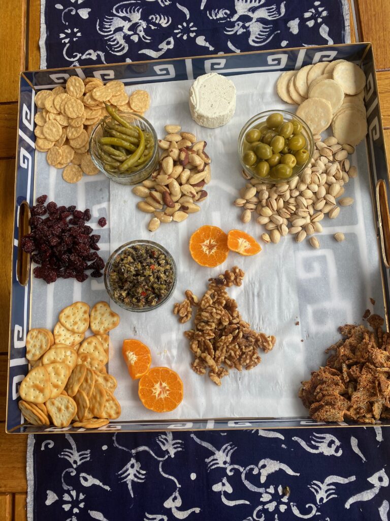 Splendid Party platter, crackers, pistachio nuts, dried sour cherries, blue and white tray, pickled peppers, olives, splendid fêtes, splendid food, Brazil nuts, cut oranges, Boursin cheese, tapenade 