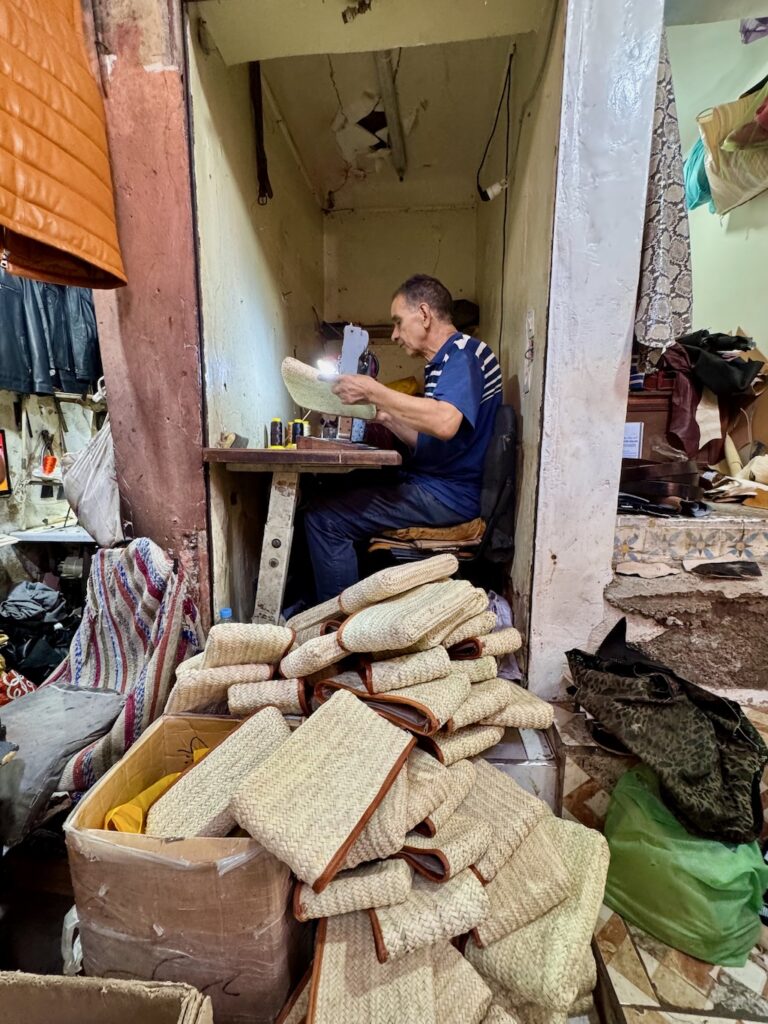 Souk, Marrakech, Medina, man stitching pouches